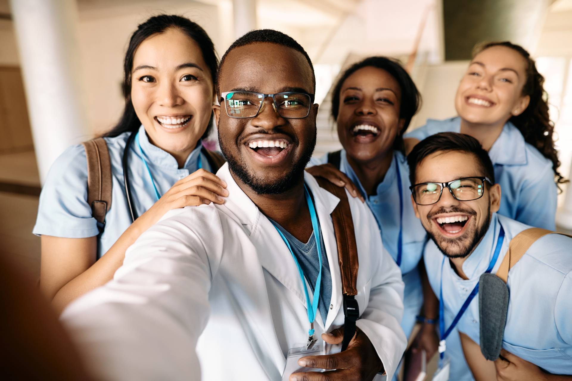 people dressed in hospital scrubs smile for a selfie together
