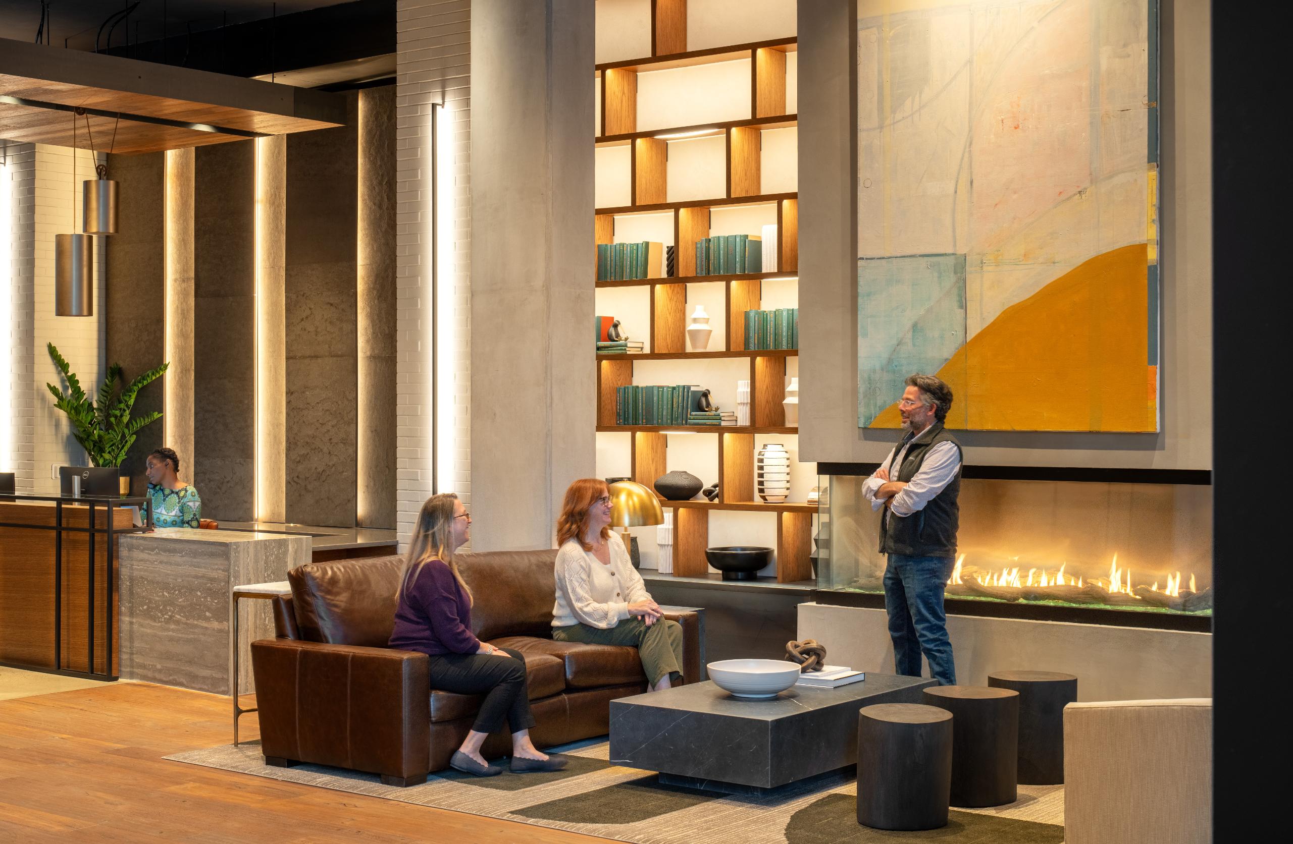 Lobby with seating, fireplace, and people
